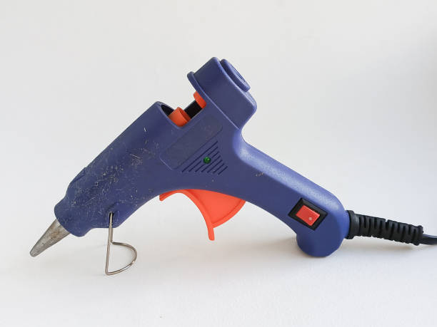 istock A hot glue gun on a white table. Blue hot glue for gluing various objects, cardboard. Refractory glue for decorative elements. 2189897751
