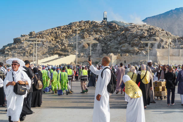 Close-up A male pilgrim in a white traditional Arab dress kandura takes a selfie with the holy mountain of Arafat in the background. Saudi Arabia, Mecca, November 23, 2024.
