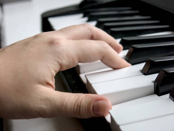 istock one hand playing electric piano 2189901479