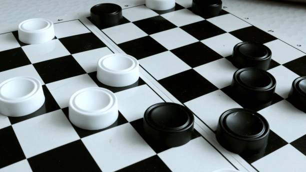 istock checkers game, hobby. Close-up of a hand moving checkers, fast shooting effect 2189902005