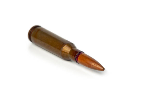 Old bullet for an automatic rifle 5.45 on a white background. Selective focus.