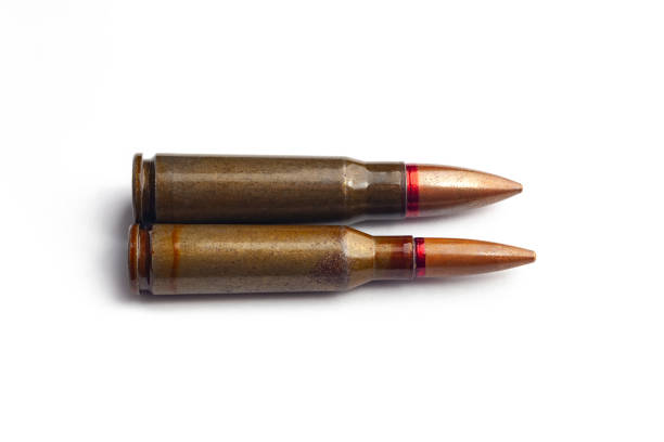 Two old bullets for automatic rifles of 5.45 and 7.62 caliber on a white background. Selective focus.