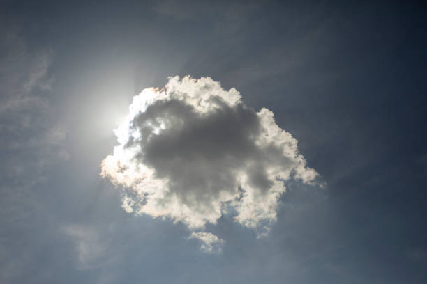 .A cloud covers the sun. A small cloud in the sky. The sun shines through the cloud. Weather details.