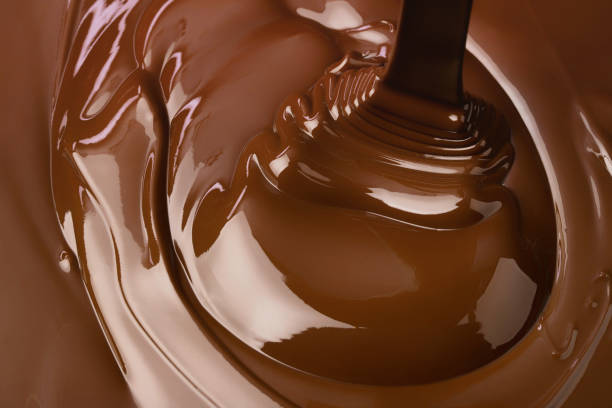 istock pouring chocolate background. cocoa syrup flowing forming ripples 2189914390