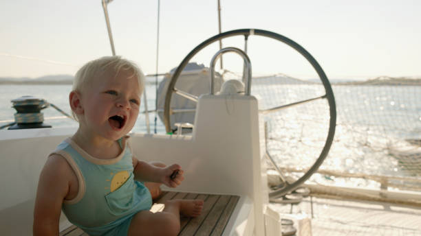 istock Joyful Baby Boy Sitting by the Helm on a Sunlit Boat Deck 2189921391