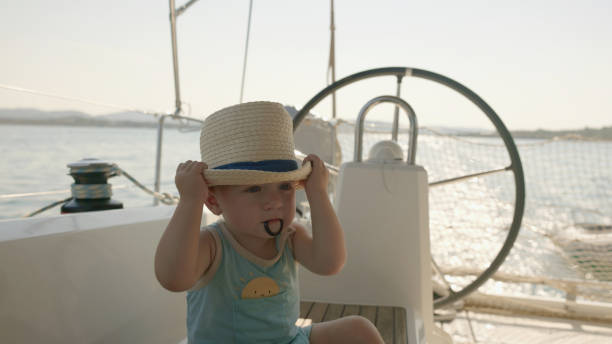 istock Baby Boy in Straw Hat Relaxing on Boat Deck Near Helm 2189921394