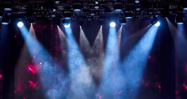 istock Bright stage spotlights shining through the smoke on a dark background 2189922261