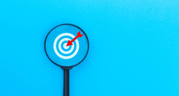 istock Business target concept with magnifying glass and target board on blue background 2189928981