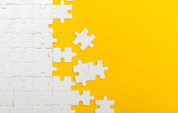istock Incomplete white puzzle pieces on yellow background 2189929094