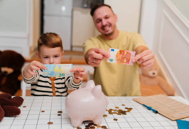 istock Father and son with piggy bank 2189932341