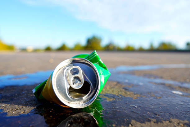 Crumpled soda can on asphalt with drink spilled. Discarded broken carbonated drink tin can on asphalt road. Problem social, crime. Thrown out Crushed juce. Crumpled Beer Can Crushed. Spilled drink.