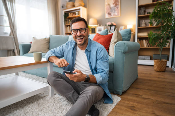istock Young cheerful man using phone at home 2189935857