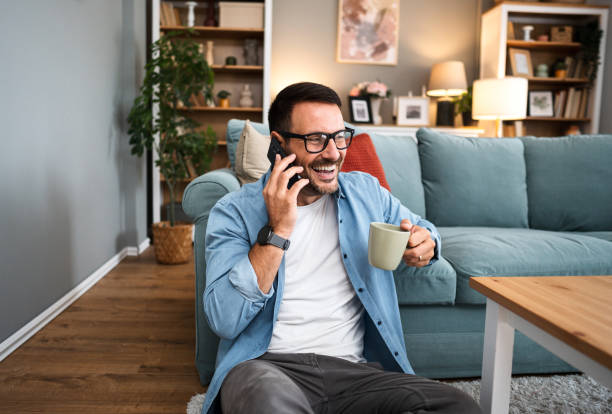 istock Young cheerful man talking on the phone at home 2189936075