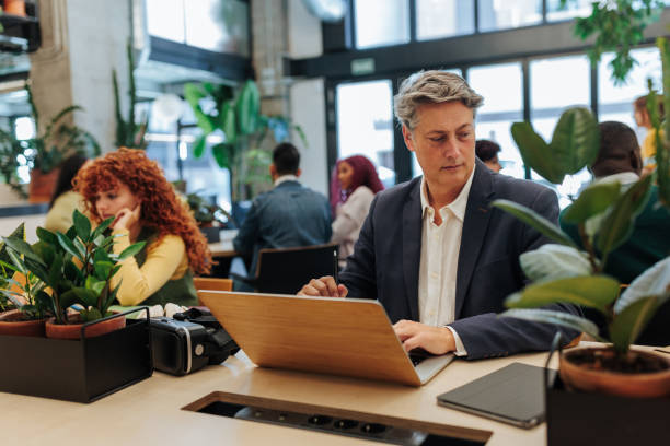 istock Focused businessman working on laptop in modern green office 2189940831