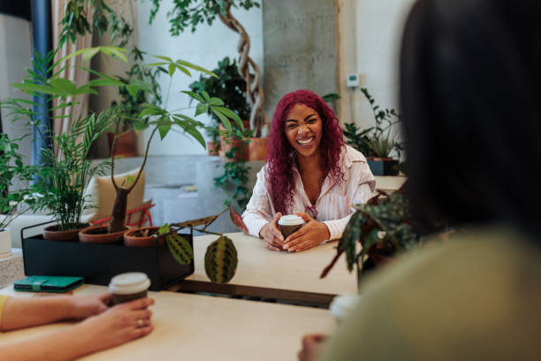 istock Young entrepreneur laughing during a coffee break with colleagues in a green office 2189940887
