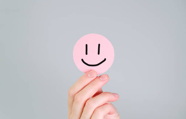 istock A hand holding a pink smiley face sticker 2189941435