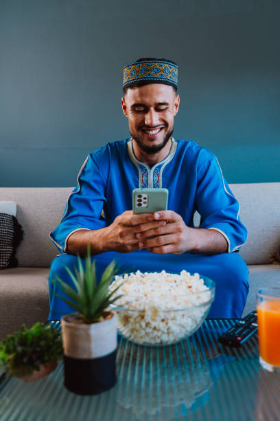 istock Moroccan guy with traditional outfit eating popcorn. 2189941817