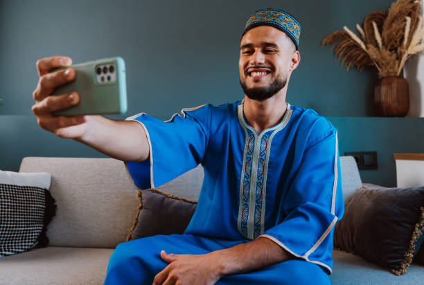 istock Moroccan guy with traditional outfit using smartphone. 2189941839