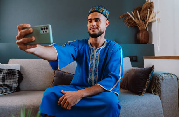 istock Moroccan guy with traditional outfit using smartphone. 2189941865