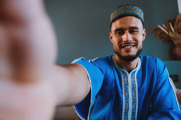 istock Moroccan guy with traditional outfit using smartphone. 2189941914