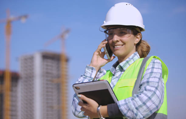 istock Female civil engineer talking with her smartphone at the construction site. 2189944671