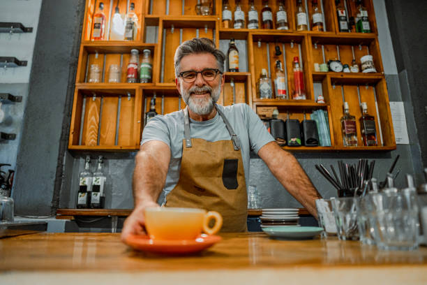 istock Barista serving a cup of coffee on a bar counter 2189945436