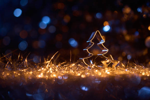 istock Glowing Christmas Tree and Star Cookie Cutters with Festive Lights and Glittery Background 2189945897