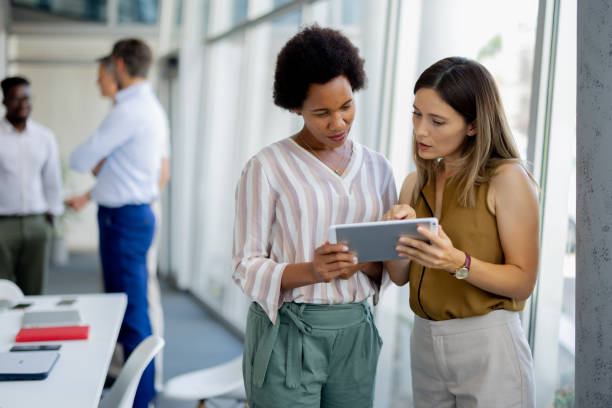 istock Professional Mixed-Race Women Collaborating on Digital Tablet in Office 2189956928