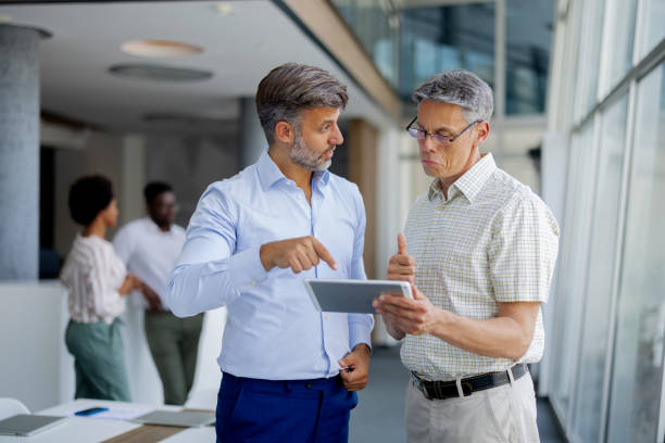 istock Team of Businessmen Discussing Work While Using Digital Tablet in Office 2189956931