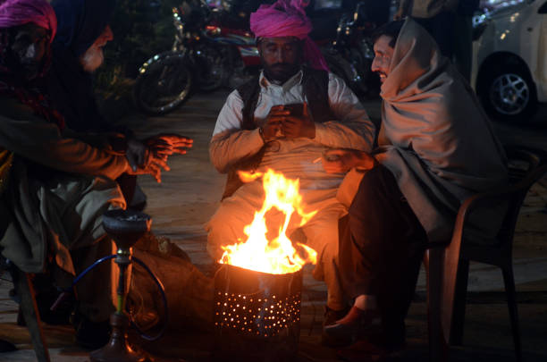 rawalpindi, pakistan : people warm their hands on bone-fire to save themselves from cold waves during the winter season, at waris khan area in rawalpindi on saturday, december 14, 2024.the pakistan meteorological department on Friday forecast for rawalpindi dry with chilly night in the next 24 hours, while temperature may drop to 6 C. the met Office said the minimum mercury level recorded during the last day was 7.4 C.