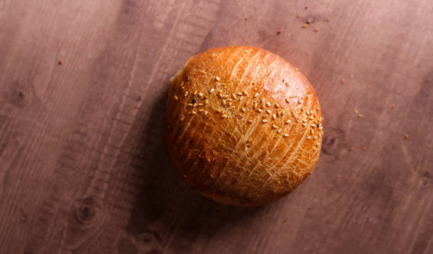 A close-up top view of a freshly baked sesame seed bun.