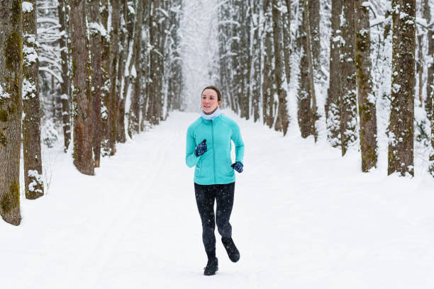 istock middle aged woman runs in winter park 2189984772