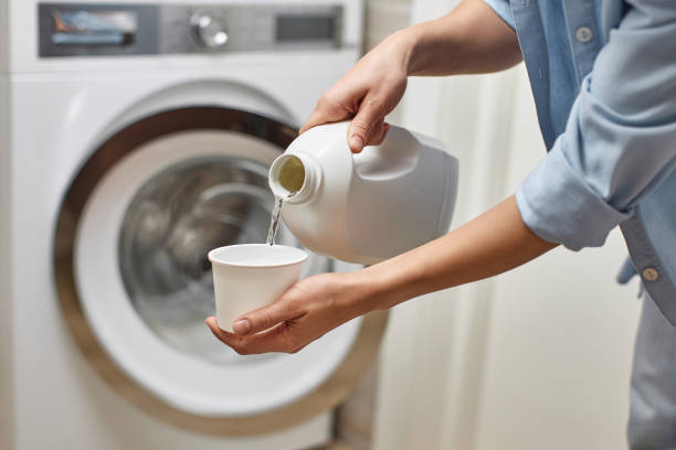 istock Woman pours liquid laundry detergent into plastic cap 2189985107