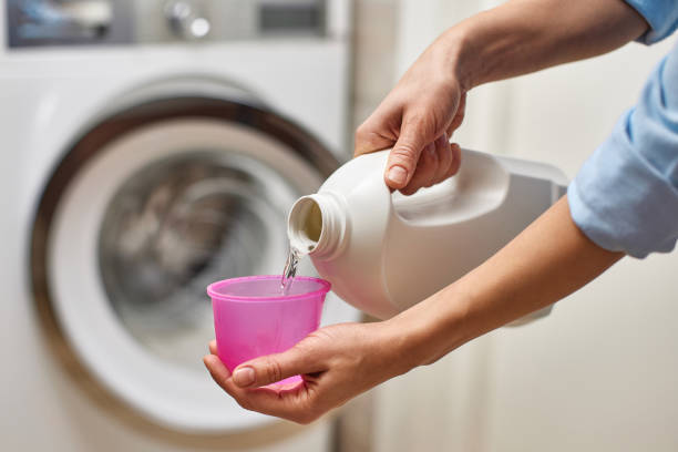 istock Woman pours liquid laundry detergent into plastic cap 2189985109