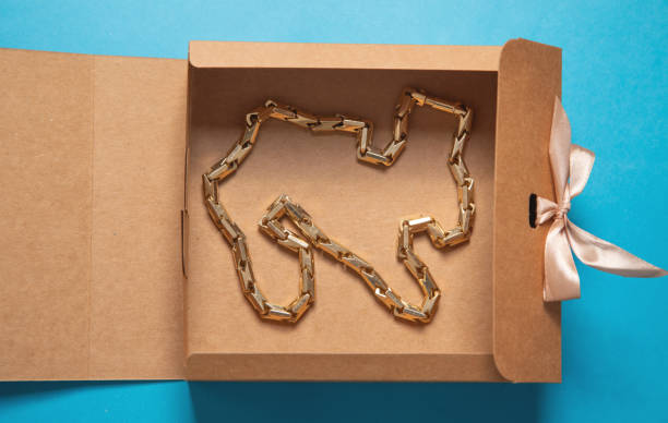 istock Gift box with a gold necklace on the blue background. 2189990178