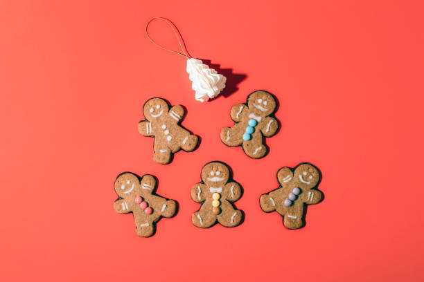 istock Gingerbread cookies with colorful decorations arranged with festive ornaments on a red background. Top view, flat lay 2189993143