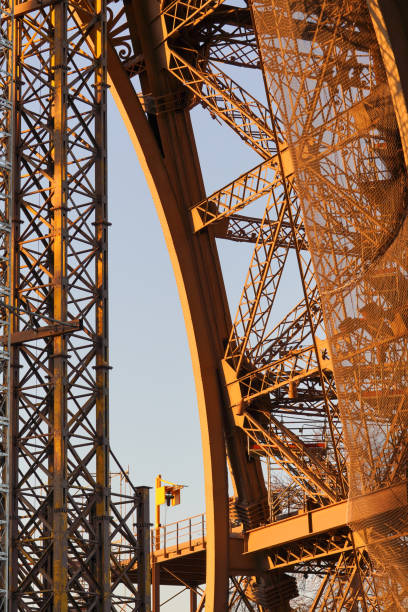 Detailed view of the Eiffel Tower's intricate iron lattice structure during golden hour.