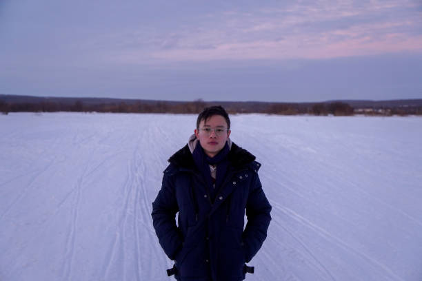 istock Man Standing on Snow-Covered Field at Dusk 2189997696