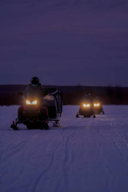 istock Snowmobilers Riding Across Winter Landscape at Dusk 2189997708