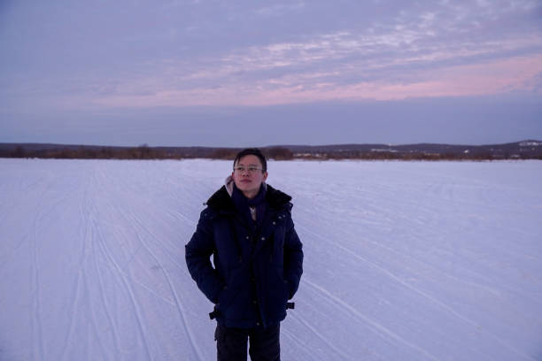 istock Man Standing on Snow-Covered Field at Dusk 2189997714
