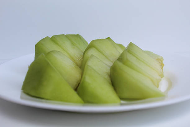 Small cuts green cantaloupe or melons, on white plate, isolated on white background