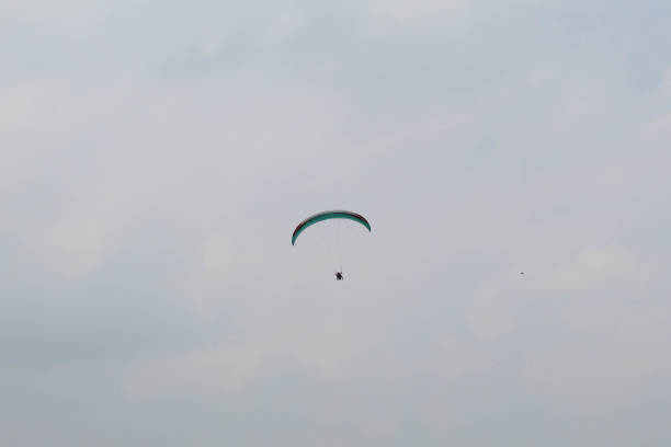 One parachute of paragliding on cloudy sky background