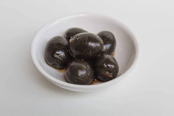 istock Table olives or fermented black olive, in small white bowl, isolated on white background 2190001769