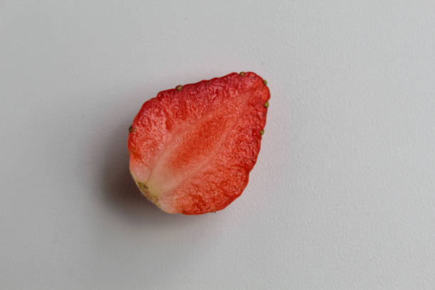 One piece of halved fresh strawberry, isolated on white background