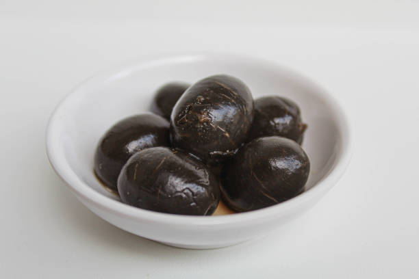istock Table olives or fermented black olive, in small white bowl, isolated on white background 2190004028