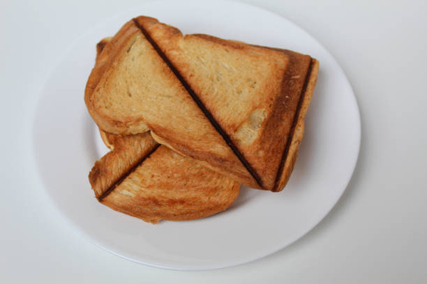 istock Some toasts or toasted breads, on white plate, isolated on white background 2190004243