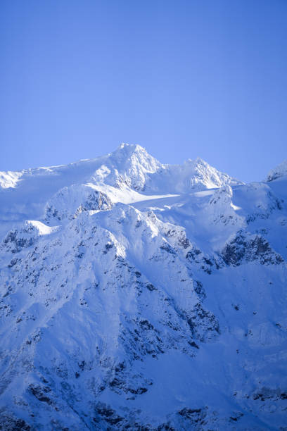 slightly veiled panorama of Mont Blanc with snow-capped peaks in summer and blue sky