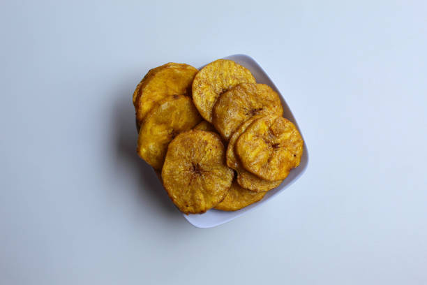 istock Sliced banana coin chips on small white bowl plate, isolated on white background 2190008764