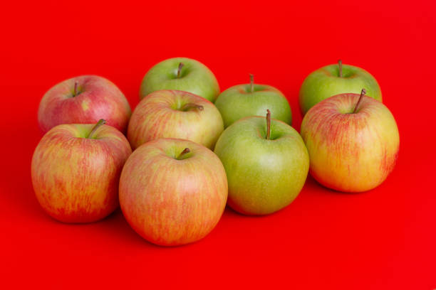 istock Apples on a red background. Red with yellow and green apples. 2190010054