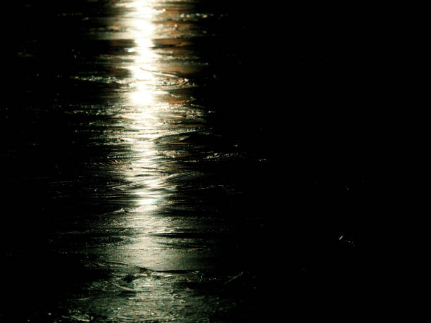 Tokyo,Japan - December 15,  2024: Reflection of lights on frozen pond surface